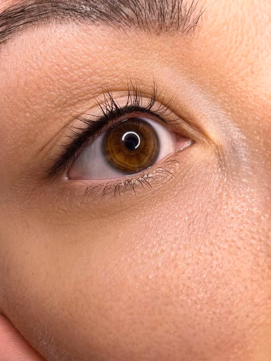 Subtle lash line enhancement eyeliner tattoo on a brown eye